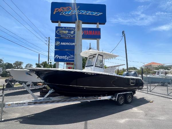 Sea Hunt Gamefish 25 2018 Sea Hunt Gamefish 25 boat on trailer at dealership, under clear blue sky.
