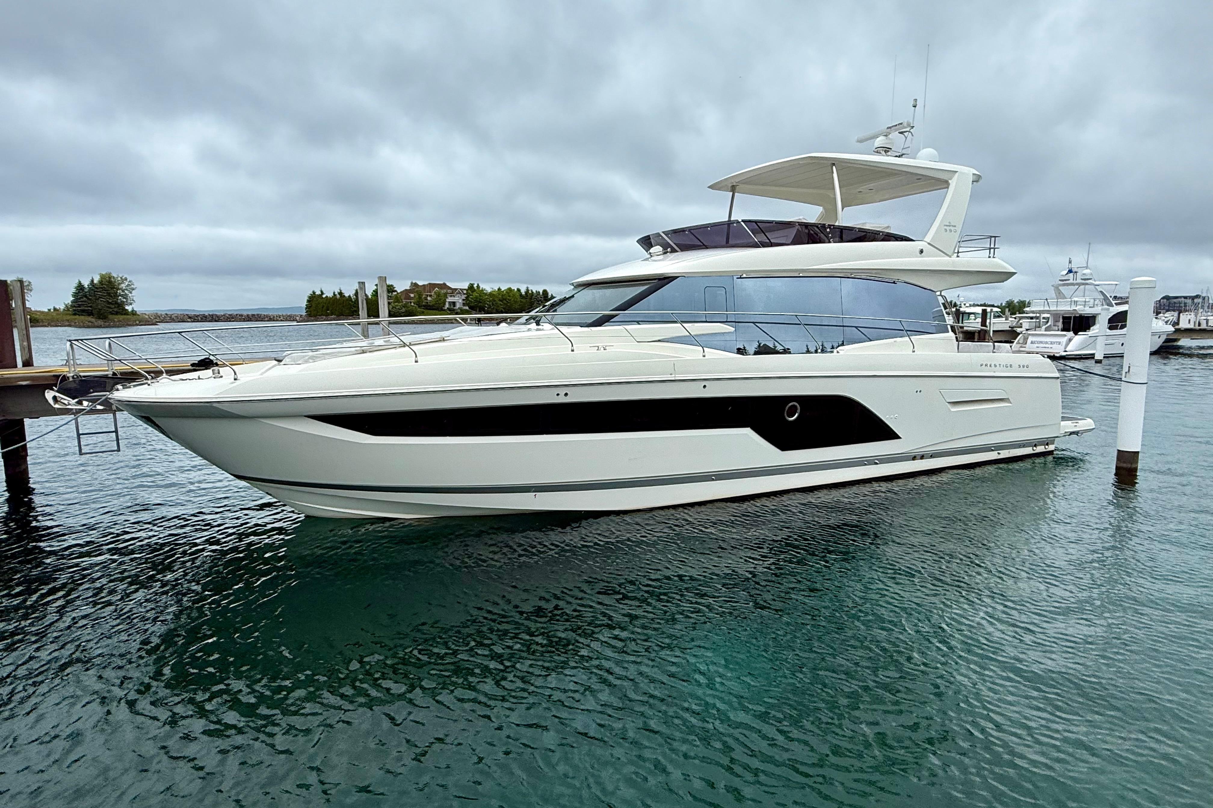 Prestige 590 Luxurious 2020 Prestige 590 yacht docked in a serene marina setting.