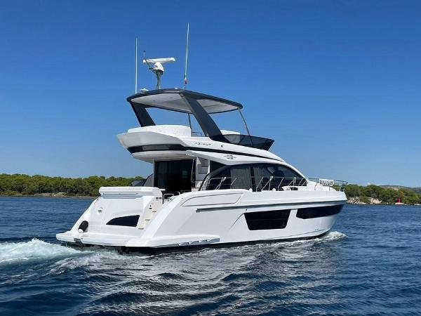 Azimut 53 Fly 2024 Azimut 53 Fly yacht cruising on a clear blue sea.