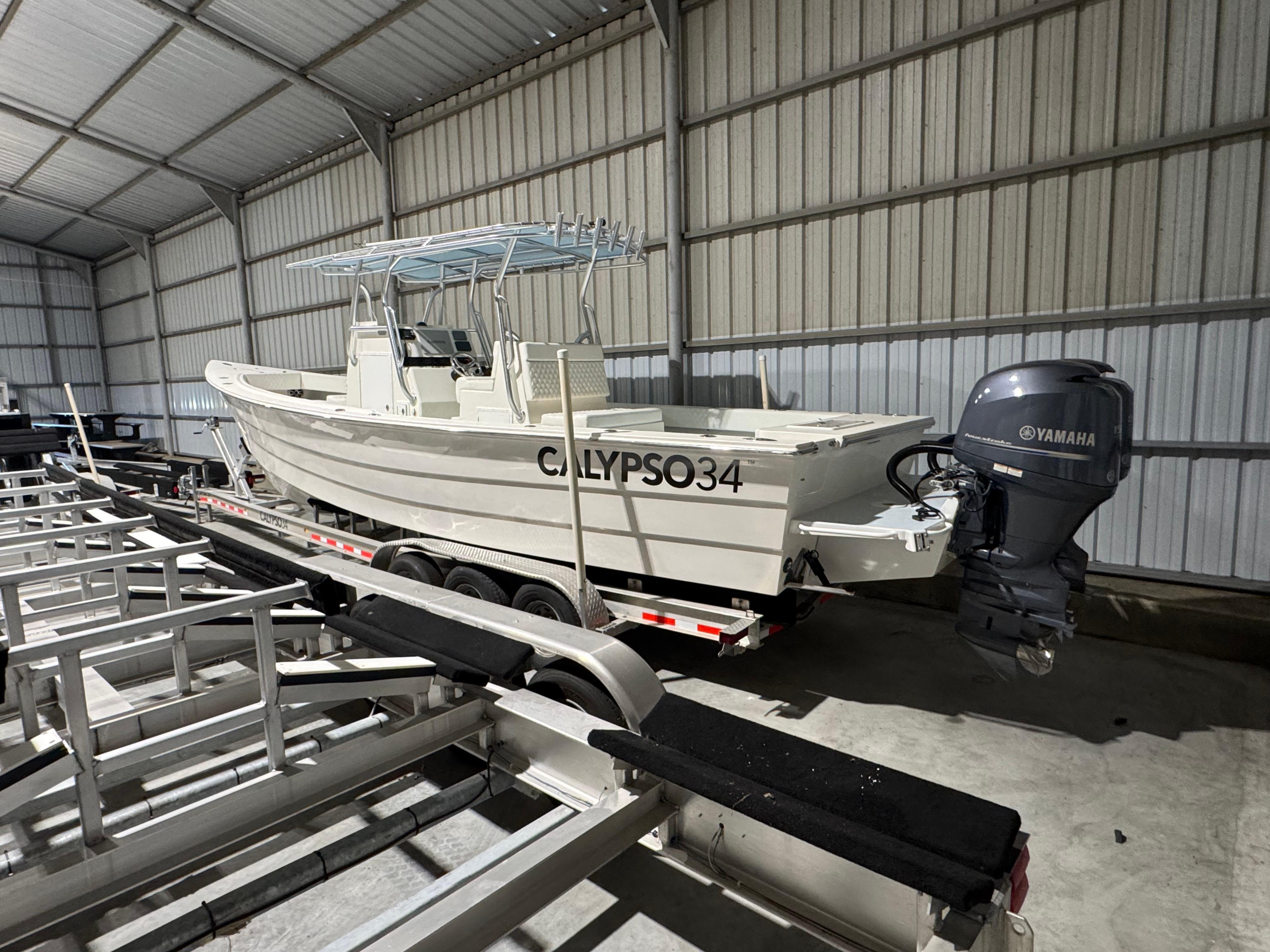 Calypso Center console 2023 Calypso Center Console boat in storage, featuring Yamaha outboard motor.
