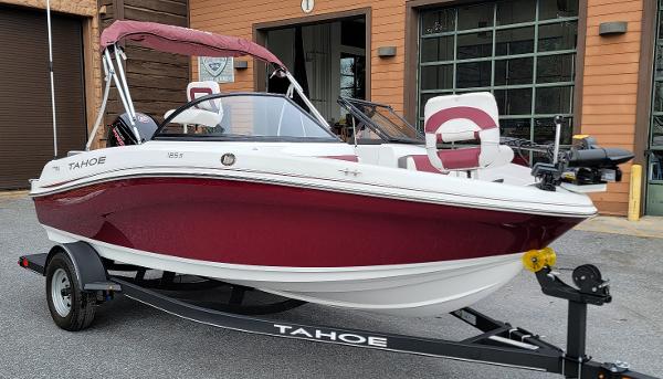 Tahoe 185 S 2024 Tahoe 185 S boat in red and white on a trailer, parked outside a building.