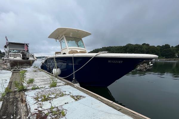Scout 255 LXF 2018 Scout 255 LXF boat docked on a calm, overcast day.