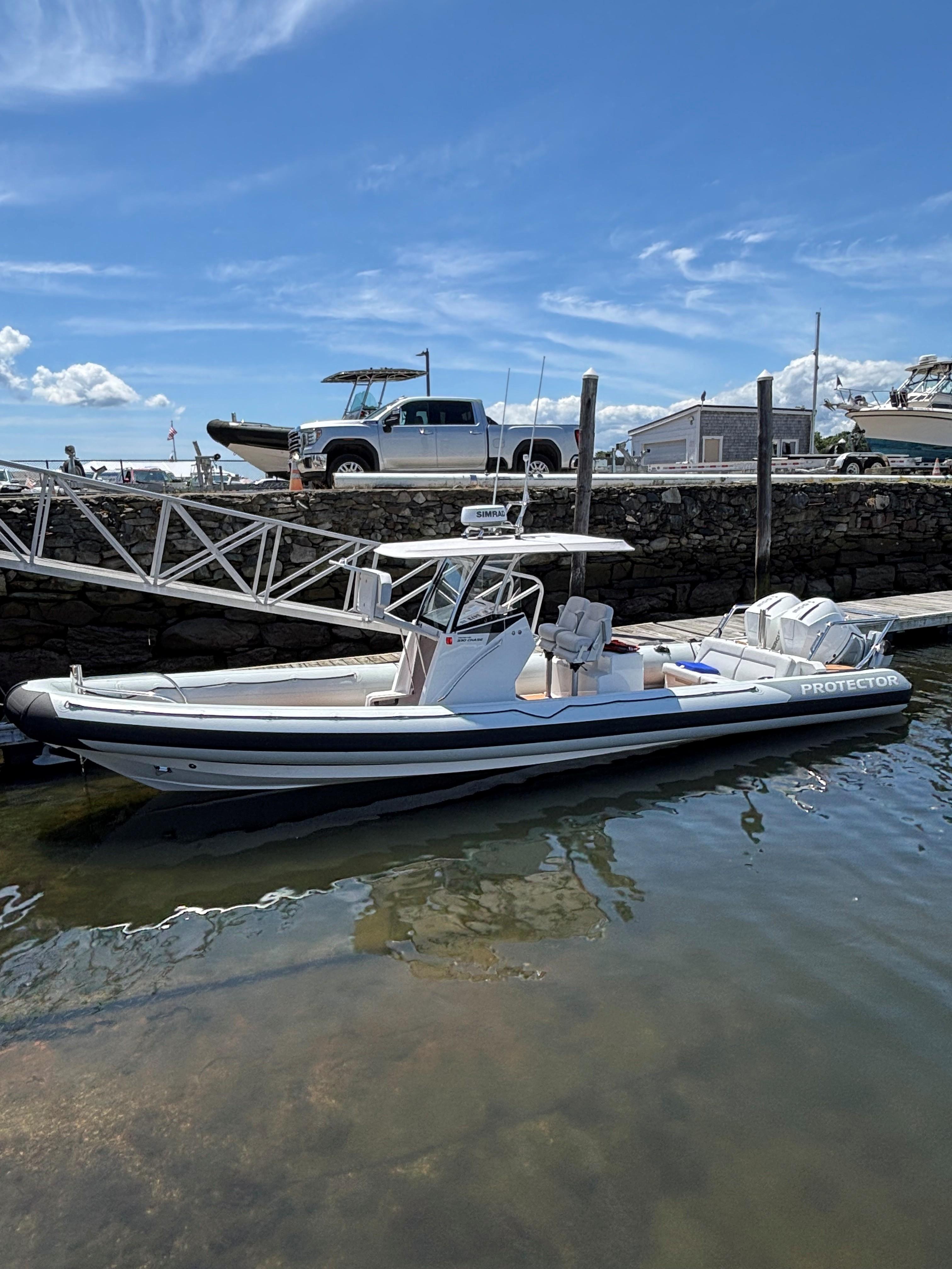 Protector 330 Chase 2025 Protector 330 Chase boat docked in a marina under a clear blue sky.