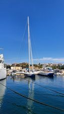 Custom ORMA 60 Sailboats docked in a marina under a clear blue sky, featuring a Custom ORMA 60 from 1990.