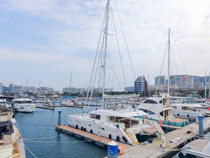 Lagoon 560 Lagoon 560 catamaran docked in a marina, surrounded by other boats, under a partly cloudy sky.