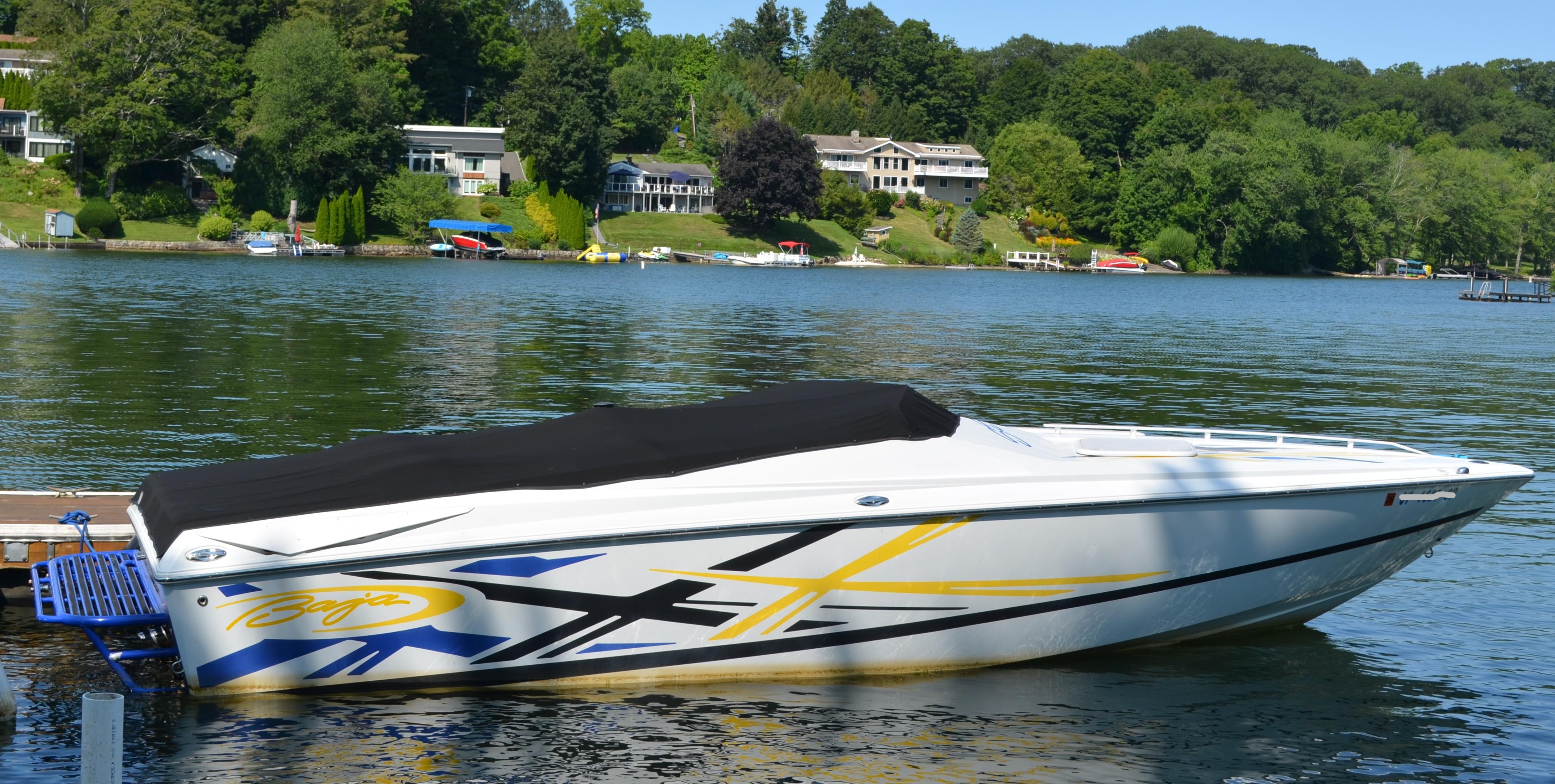 Baja 26 Outlaw 2008 Baja 26 Outlaw boat docked on a scenic lake with lush greenery.