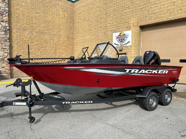 Tracker Targa V-18 Combo 2025 Tracker Targa V-18 Combo boat, red, on trailer, parked outside a building.