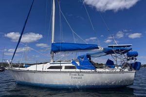 C&C 32 1983 C&C 32 sailboat with blue sails on a sunny day, named "Front Row Forward."