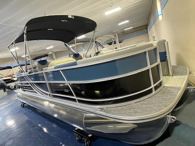 South Bay LE 2025 South Bay LE pontoon boat with canopy, displayed indoors on blue flooring.