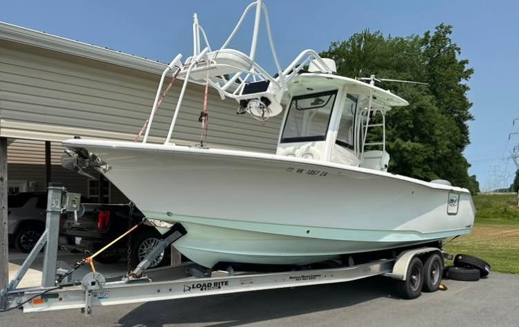 Sea Hunt Gamefish 27 2018 Sea Hunt Gamefish 27 boat on trailer, parked outdoors near a building.