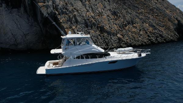 Bertram Convertible 2010 Bertram Convertible yacht anchored near rocky coastline.