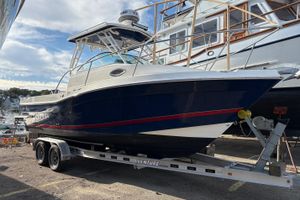 Striper 230 Walkaround 2018 Striper 230 Walkaround boat on trailer, parked outdoors under a partly cloudy sky.