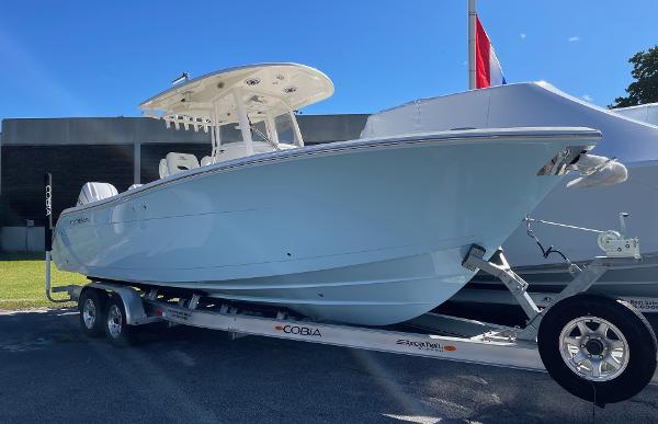 Cobia 280 Center Console 2024 Cobia 280 Center Console boat on a trailer under a clear blue sky.