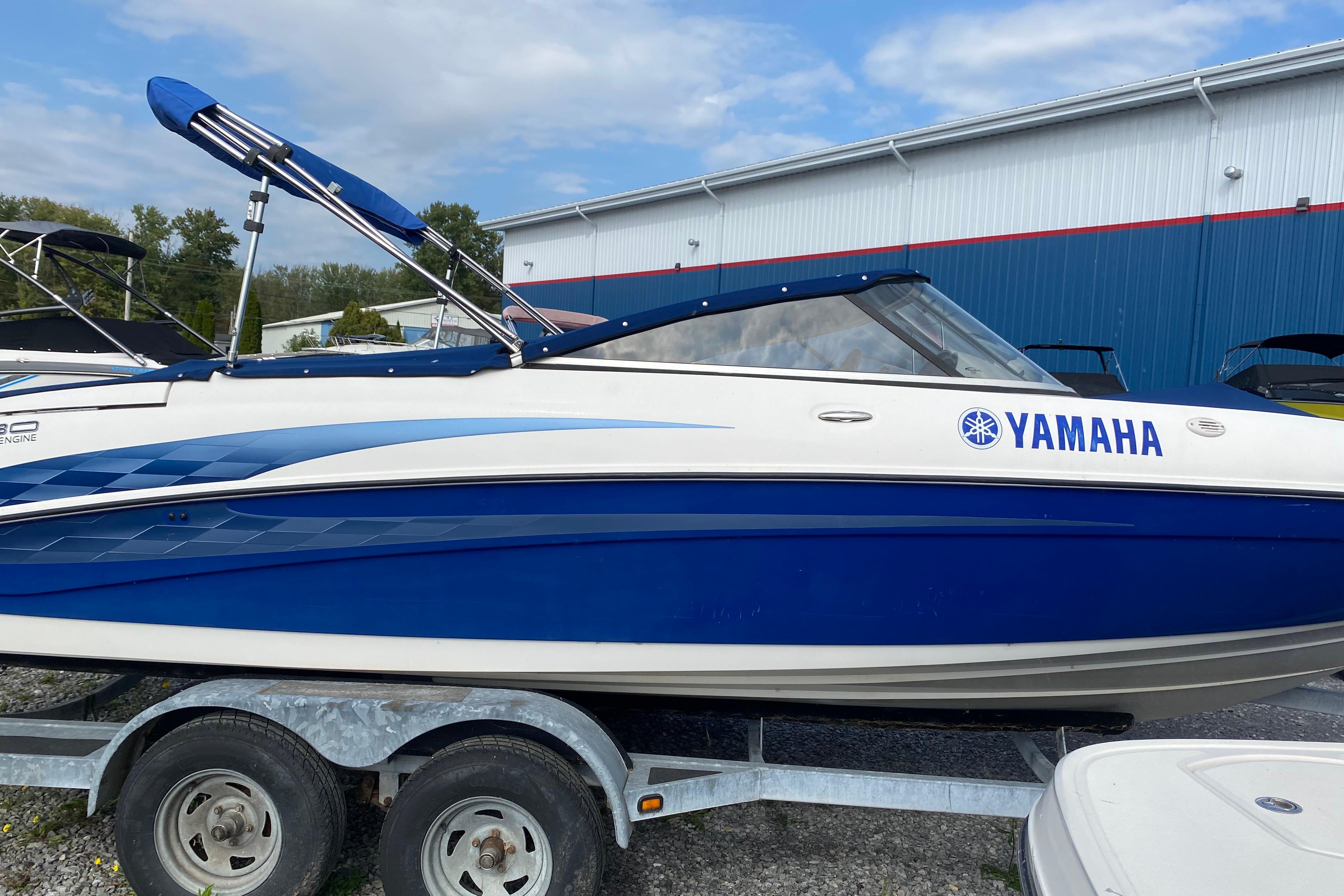 Yamaha Boats SX230 2005 Yamaha Boats SX230 on trailer, blue and white design, parked outdoors.