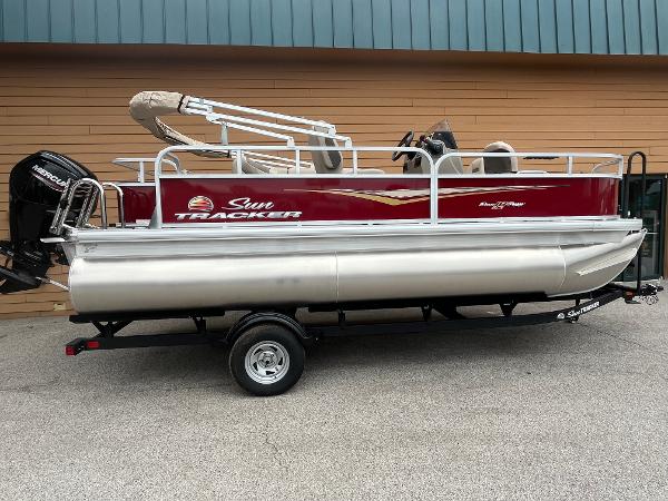 Sun Tracker Bass Buggy 18 DLX 2025 Sun Tracker Bass Buggy 18 DLX pontoon boat on trailer, side view.