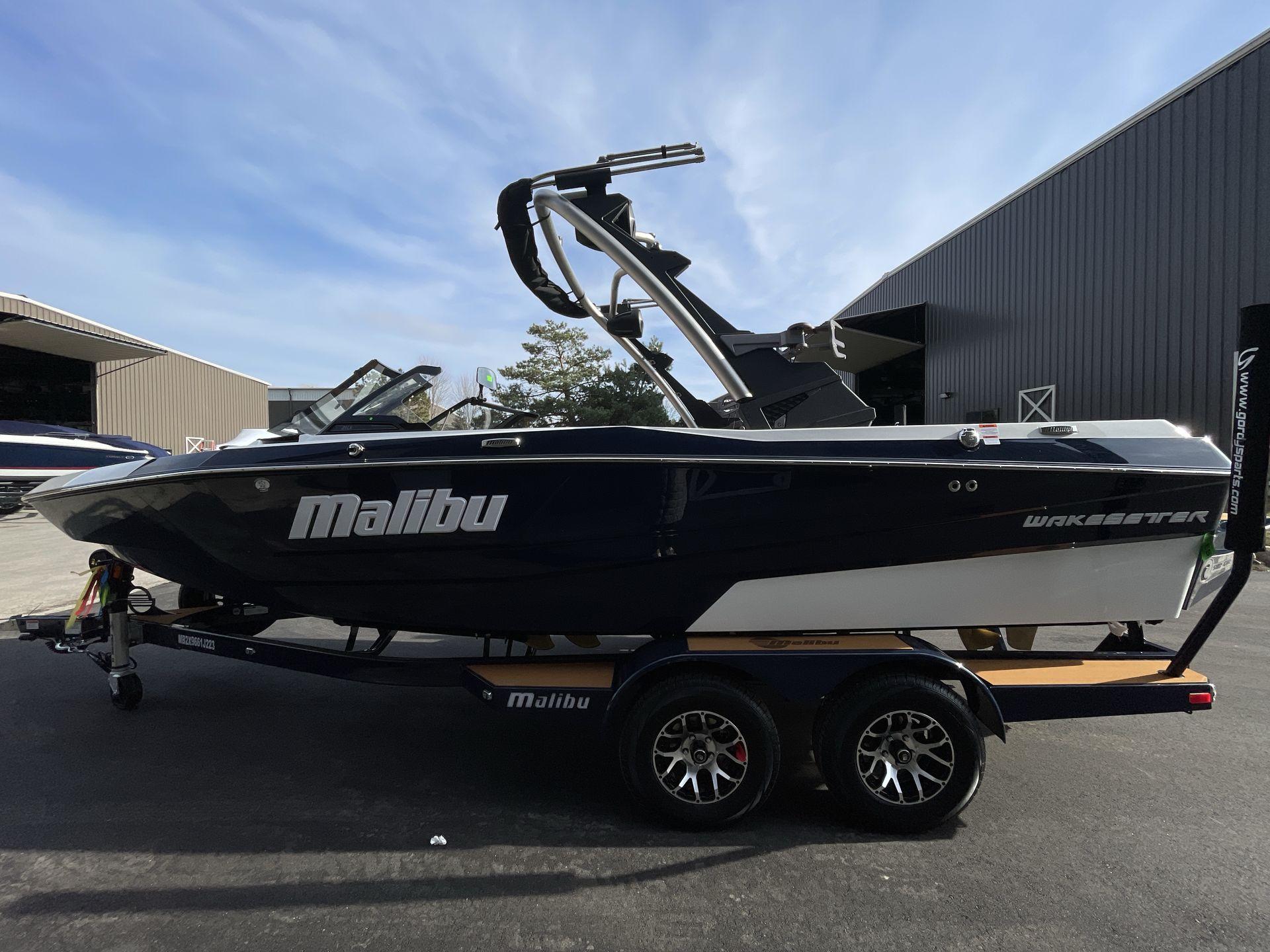 Malibu Wakesetter 21 LX 2023 Malibu Wakesetter 21 LX boat on trailer, parked outdoors.