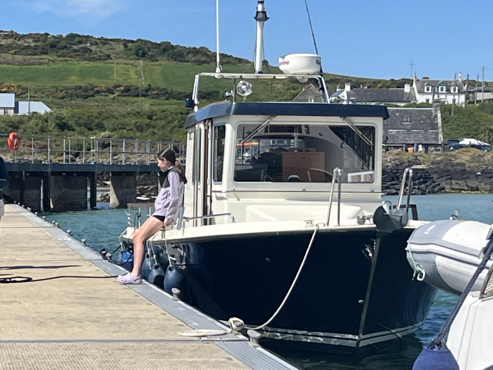 Botnia Targa 27.1 2011 Botnia Targa 27.1 docked at a scenic marina with a person sitting on the edge.