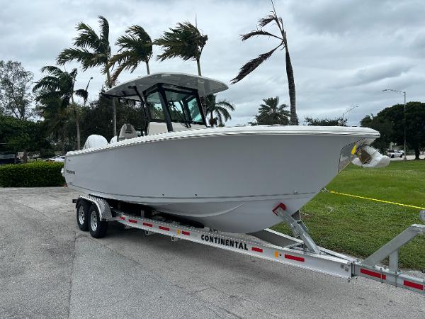 Sailfish 272 CC 2025 Sailfish 272 CC boat on trailer, parked near palm trees.