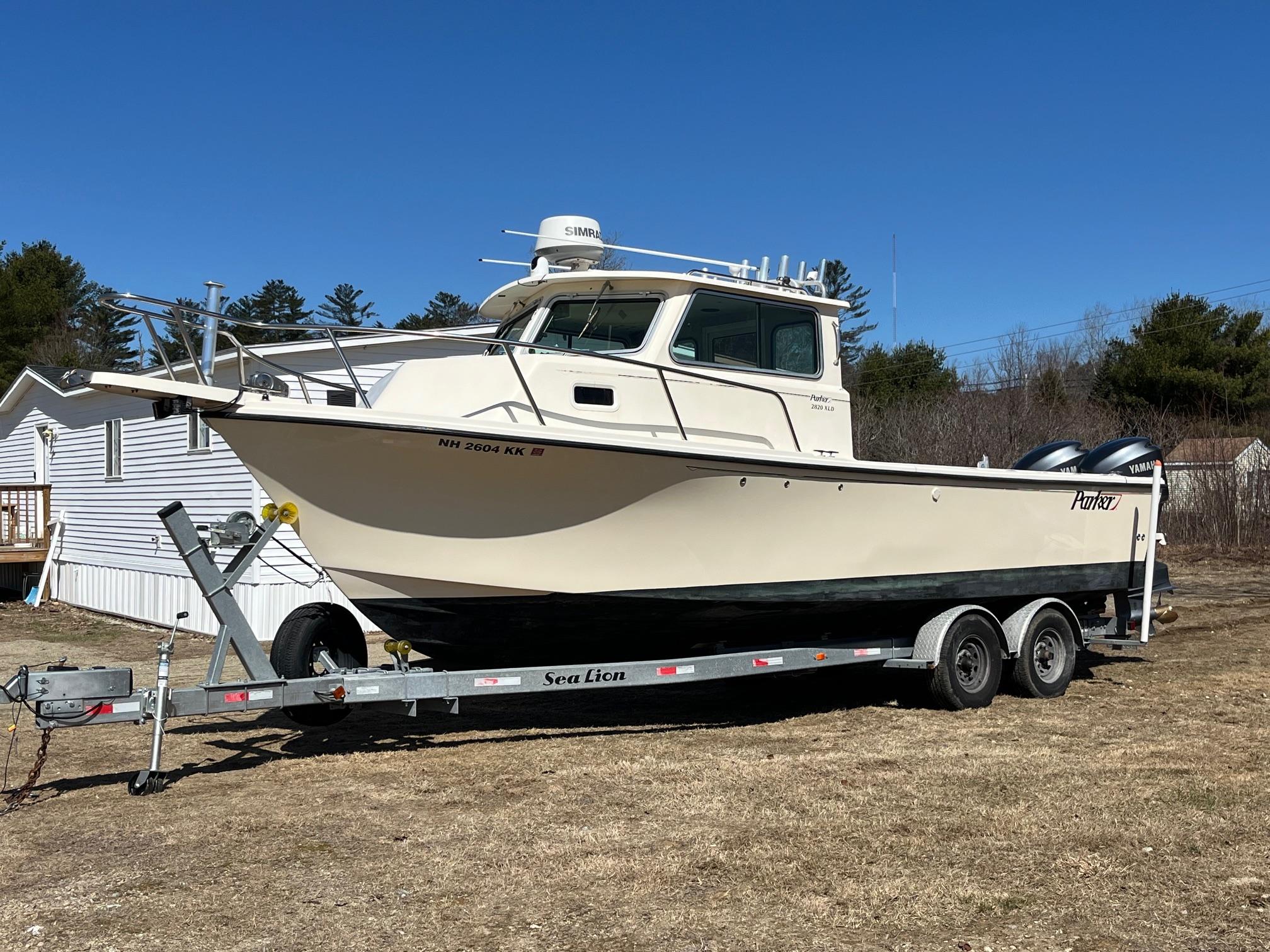 Parker 2820 XLD 2008 Parker 2820 XLD boat on trailer, parked on grass under clear blue sky.