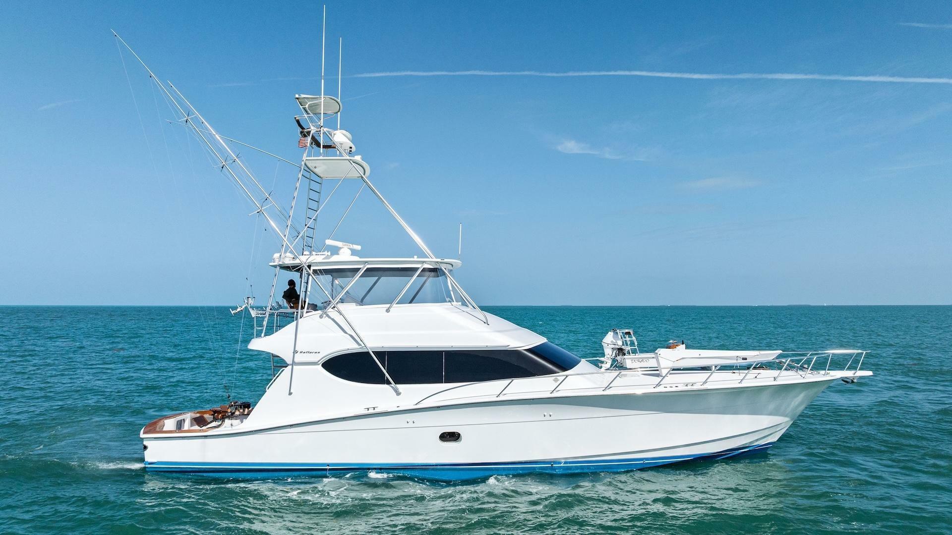 Hatteras 68 Convertible 2006 Hatteras 68 Convertible yacht cruising on open sea under clear blue sky.