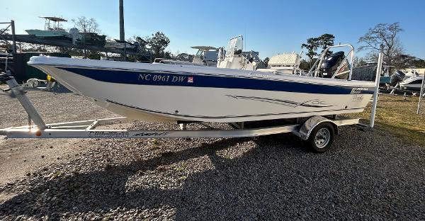Carolina Skiff 21 Ultra Elite 2012 Carolina Skiff 21 Ultra Elite boat on trailer, parked on gravel.