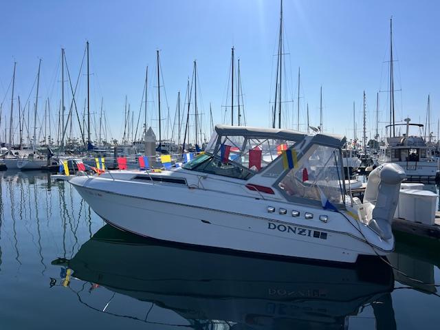 Donzi 300 Levante 1990 Donzi 300 Levante boat docked in a marina, adorned with colorful flags.