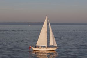 Laurent Giles 38 Sailboat Laurent Giles 38 from 1976 on calm sea at sunset.