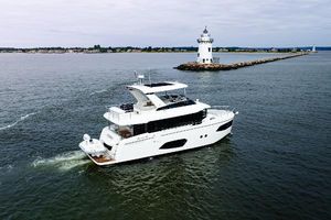 Absolute 52 Navetta 2023 Absolute 52 Navetta yacht cruising near a lighthouse on a calm sea.
