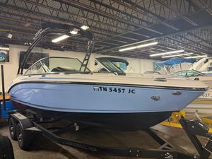 Chaparral 21 Surf 2023 Chaparral 21 Surf boat in showroom, side view with trailer.