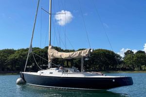 Rustler 33 2017 Rustler 33 sailboat anchored on calm water with trees in the background.