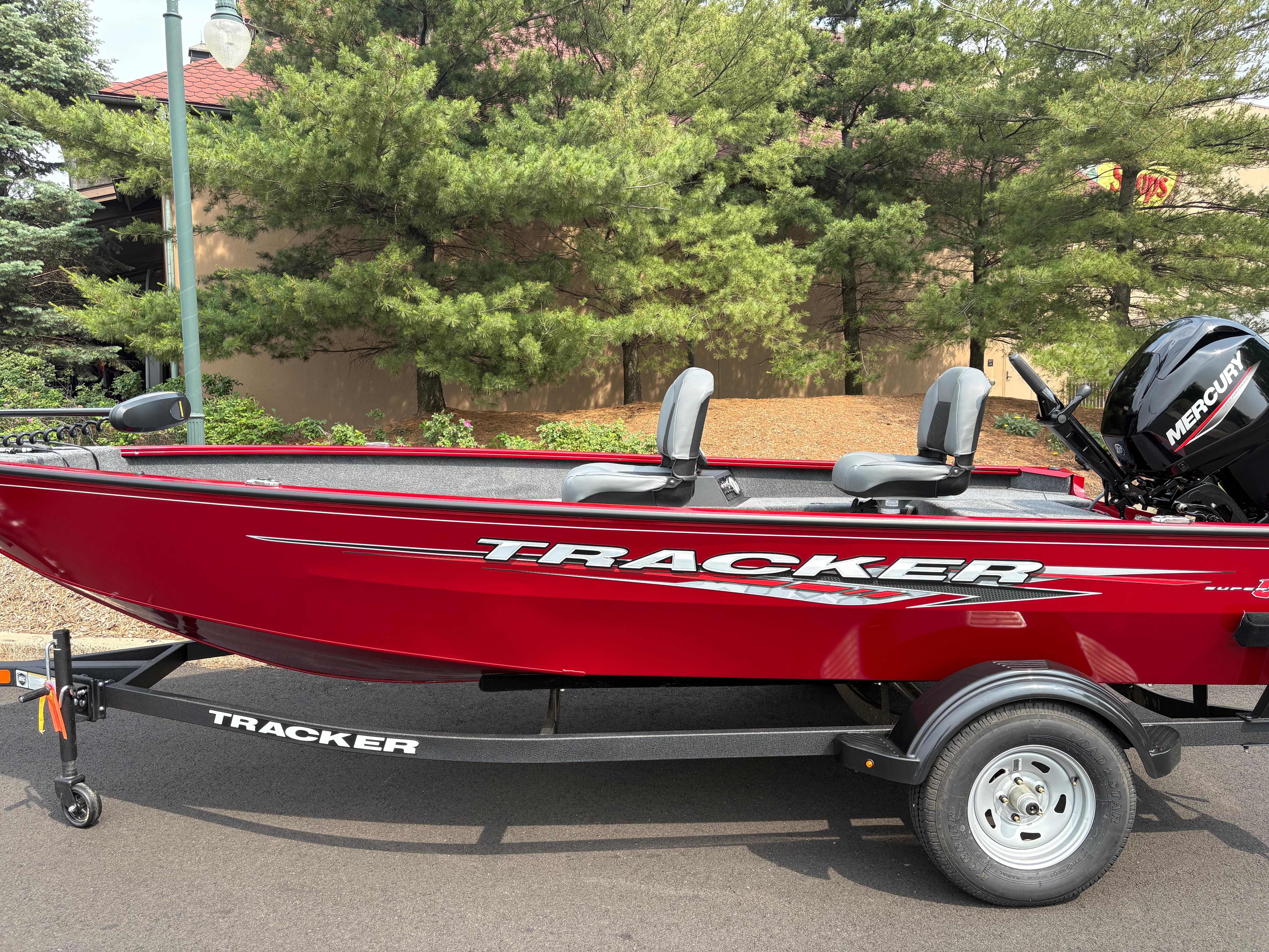 Tracker Super Guide V-16 T 2025 Tracker Super Guide V-16 T boat, red, on trailer, with Mercury engine, outdoors.