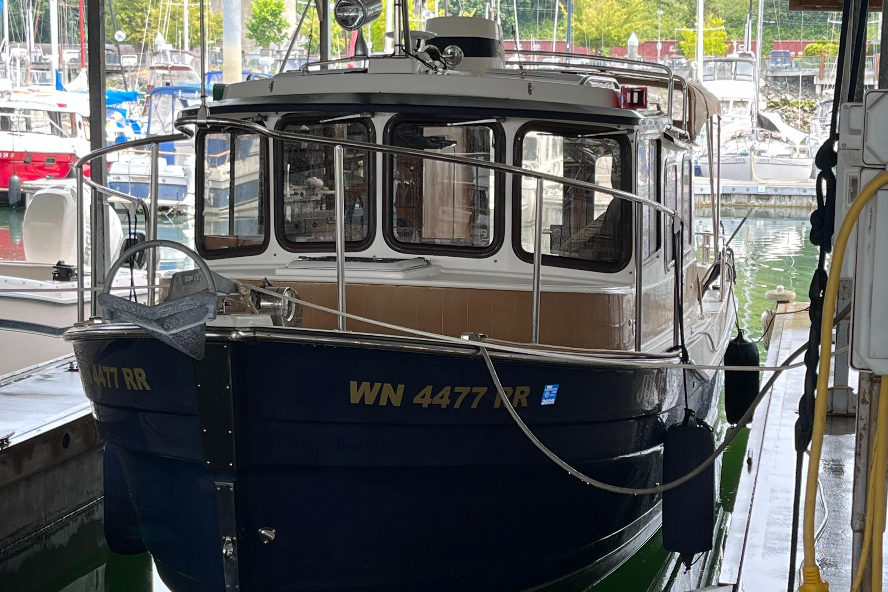 Ranger Tugs R25SC 2012 Ranger Tugs R25SC boat docked in a marina, front view.