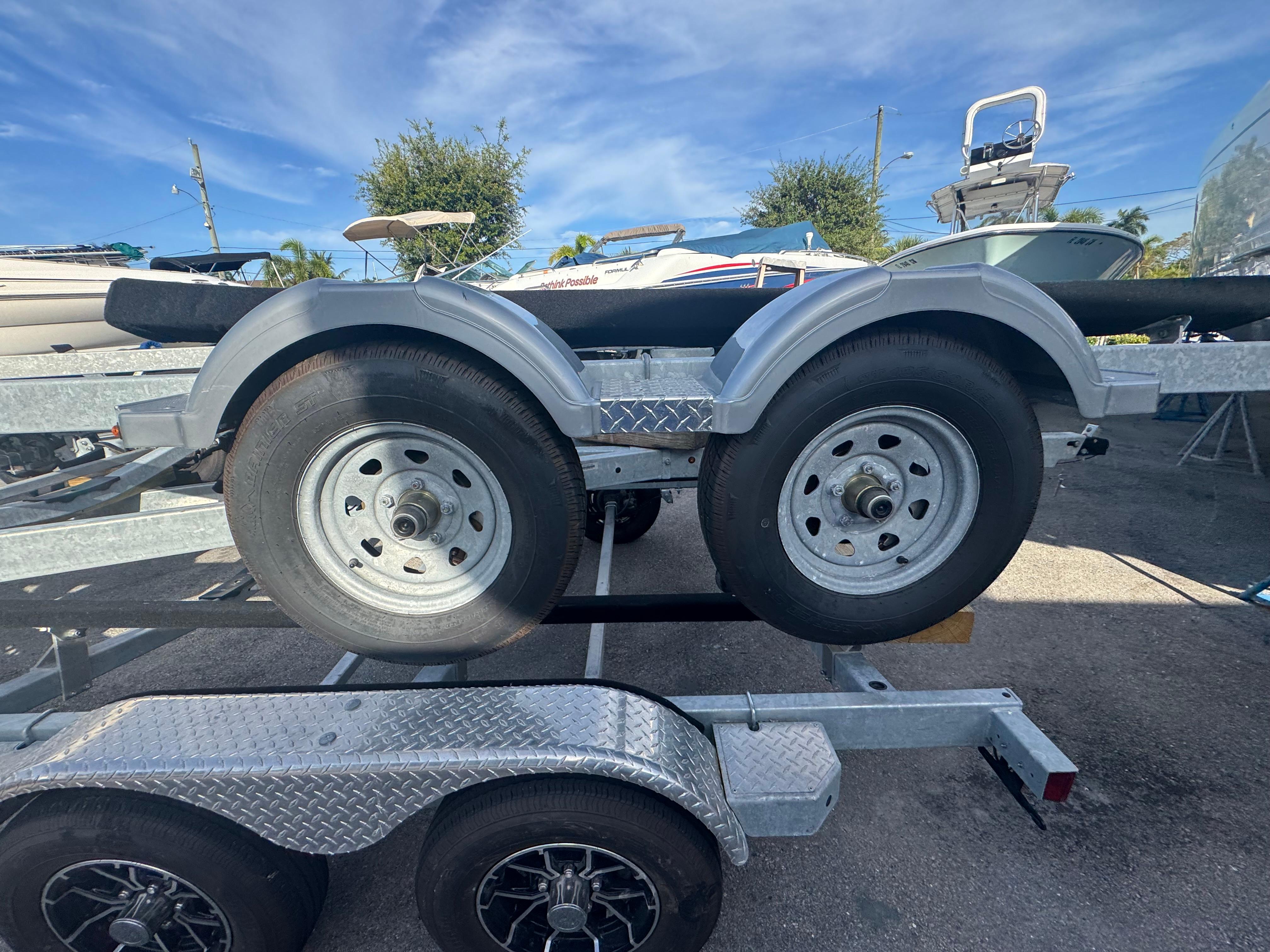 Trailer magic tilt 17-21 w/ folding tongue & brakes on all 4 tires! 2024 Magic Tilt trailer with dual wheels, parked outdoors under a clear sky.