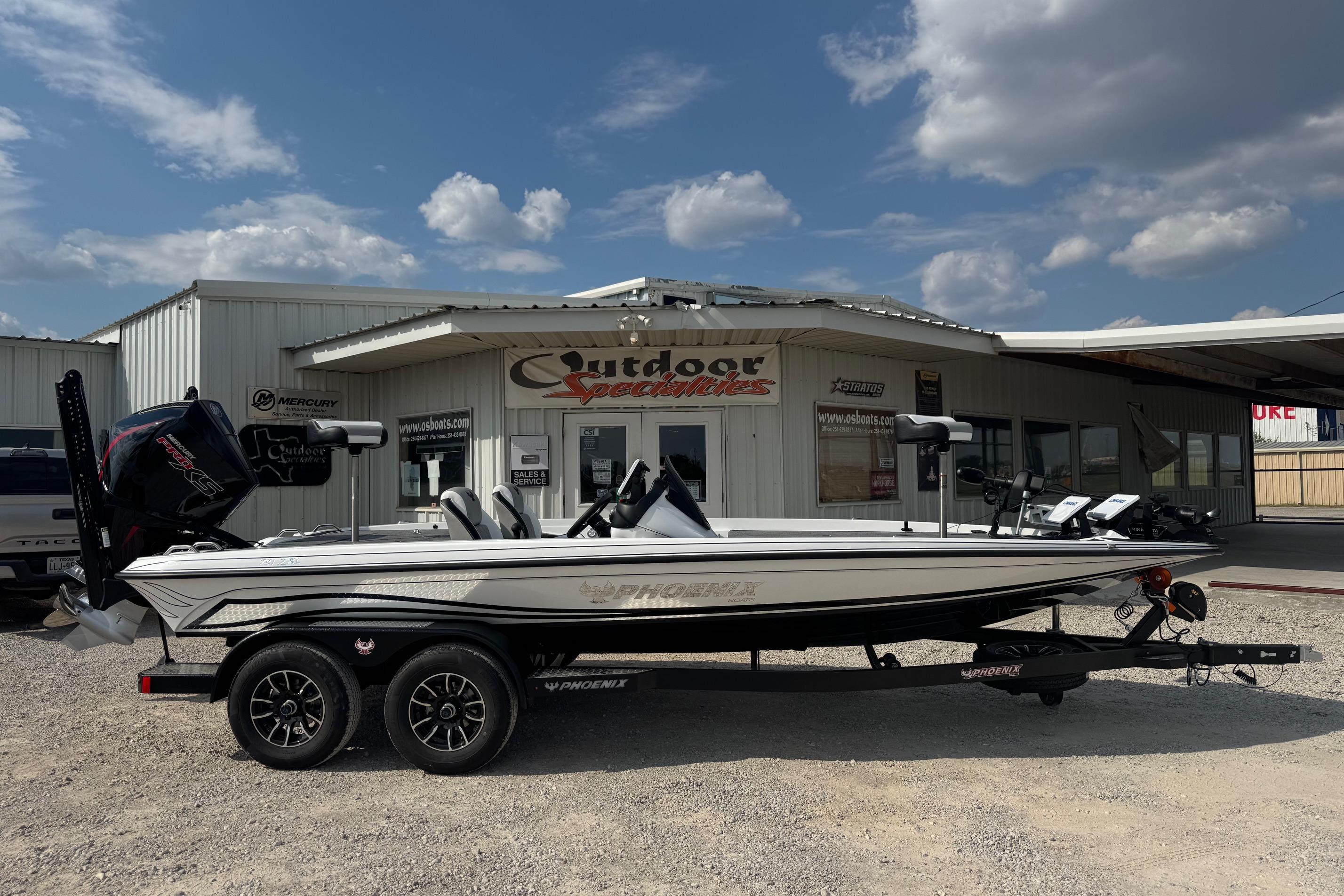 Phoenix 721 ZXL 2026 Phoenix 721 ZXL boat on trailer outside dealership under blue sky.