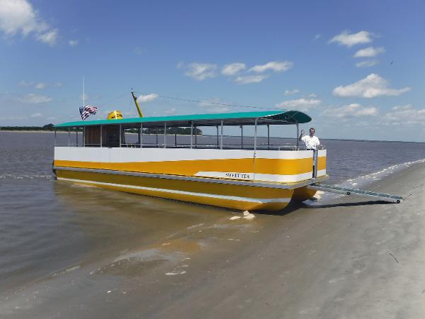 Commercial Rover Marine Lines Carolina Rover 40 Yellow and white 2016 Rover Marine Carolina Rover 40 boat on sandy shore under blue sky.
