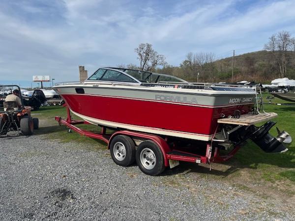 Formula Formula Three LS 1983 Formula Three LS boat on trailer, red and white, parked outdoors.