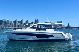 Sealine C335V 2024 Sealine C335V yacht cruising near a city skyline on a clear day.