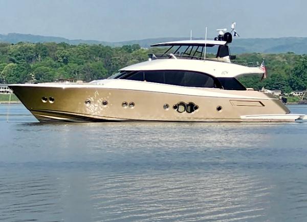 Monte Carlo Yachts 76 Luxurious 2012 Monte Carlo Yachts 76 cruising on a serene lake with lush green hills.
