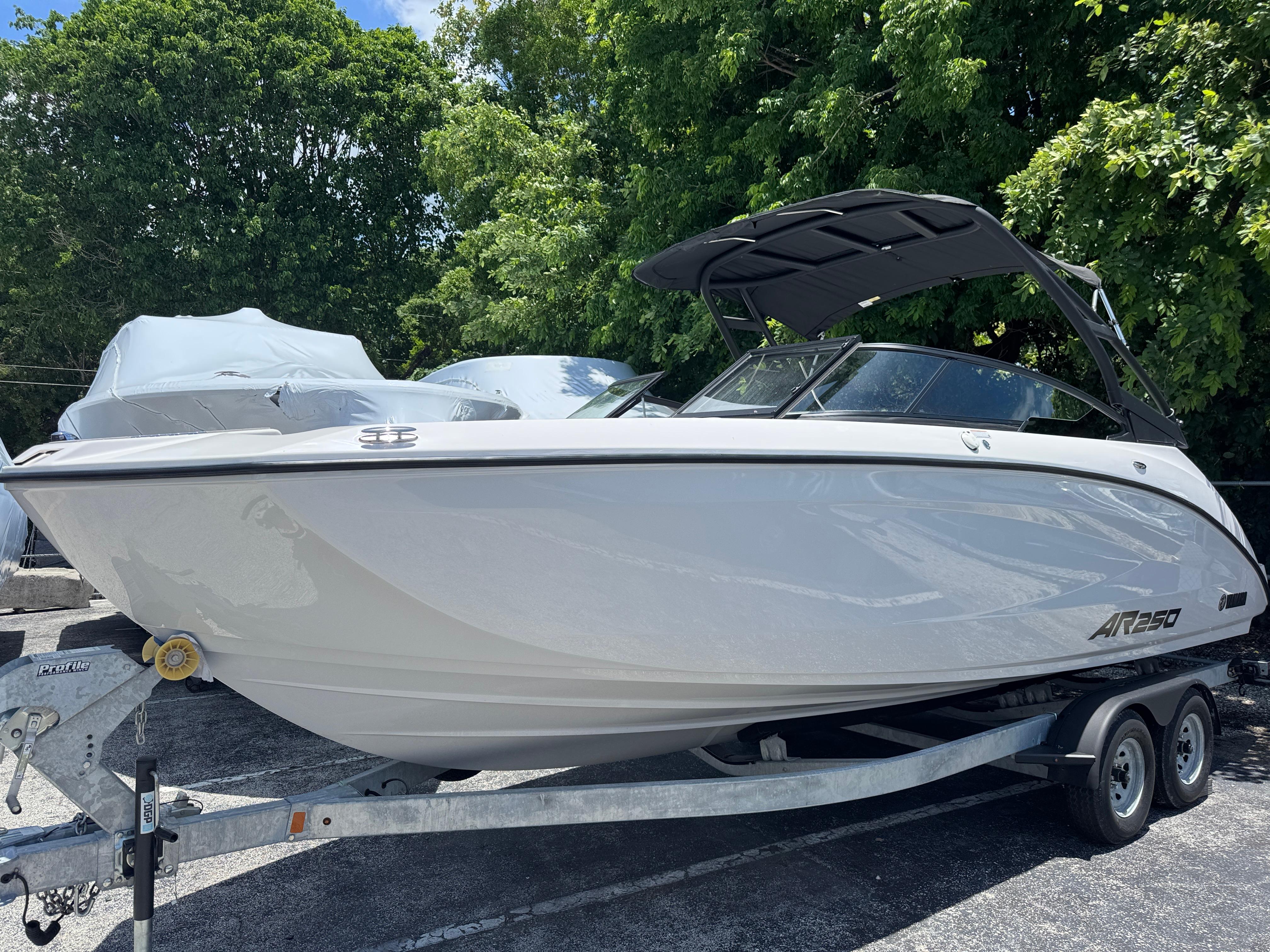 Yamaha Boats AR250 2025 Yamaha Boats AR250 on trailer, parked outdoors with trees in background.