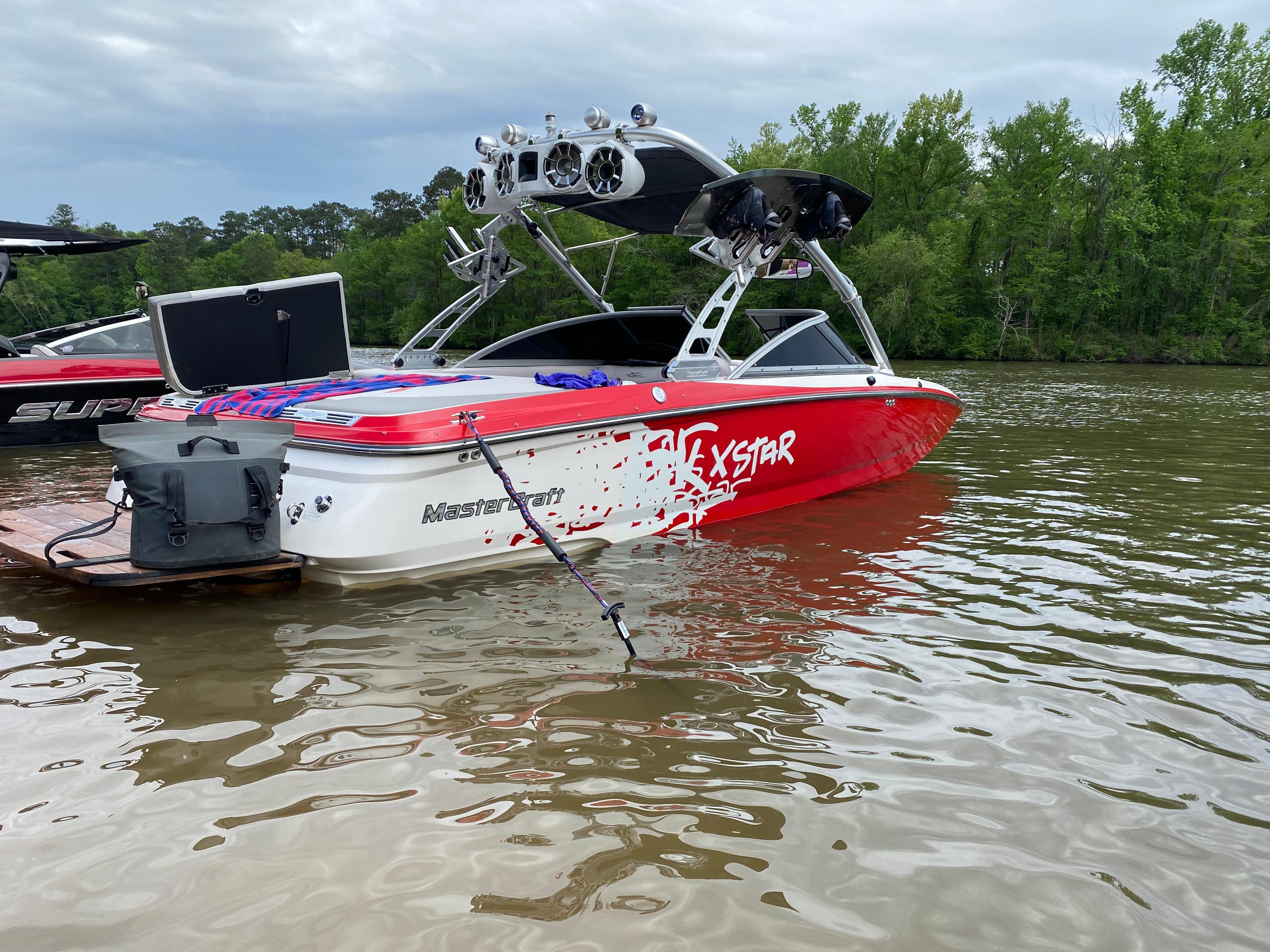 MasterCraft XStar 2006 MasterCraft XStar boat on a lake, featuring a vibrant red and white design.