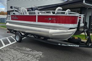 Sun Tracker Bass Buggy 18 DLX 2026 Sun Tracker Bass Buggy 18 DLX pontoon boat on trailer, red and silver design.