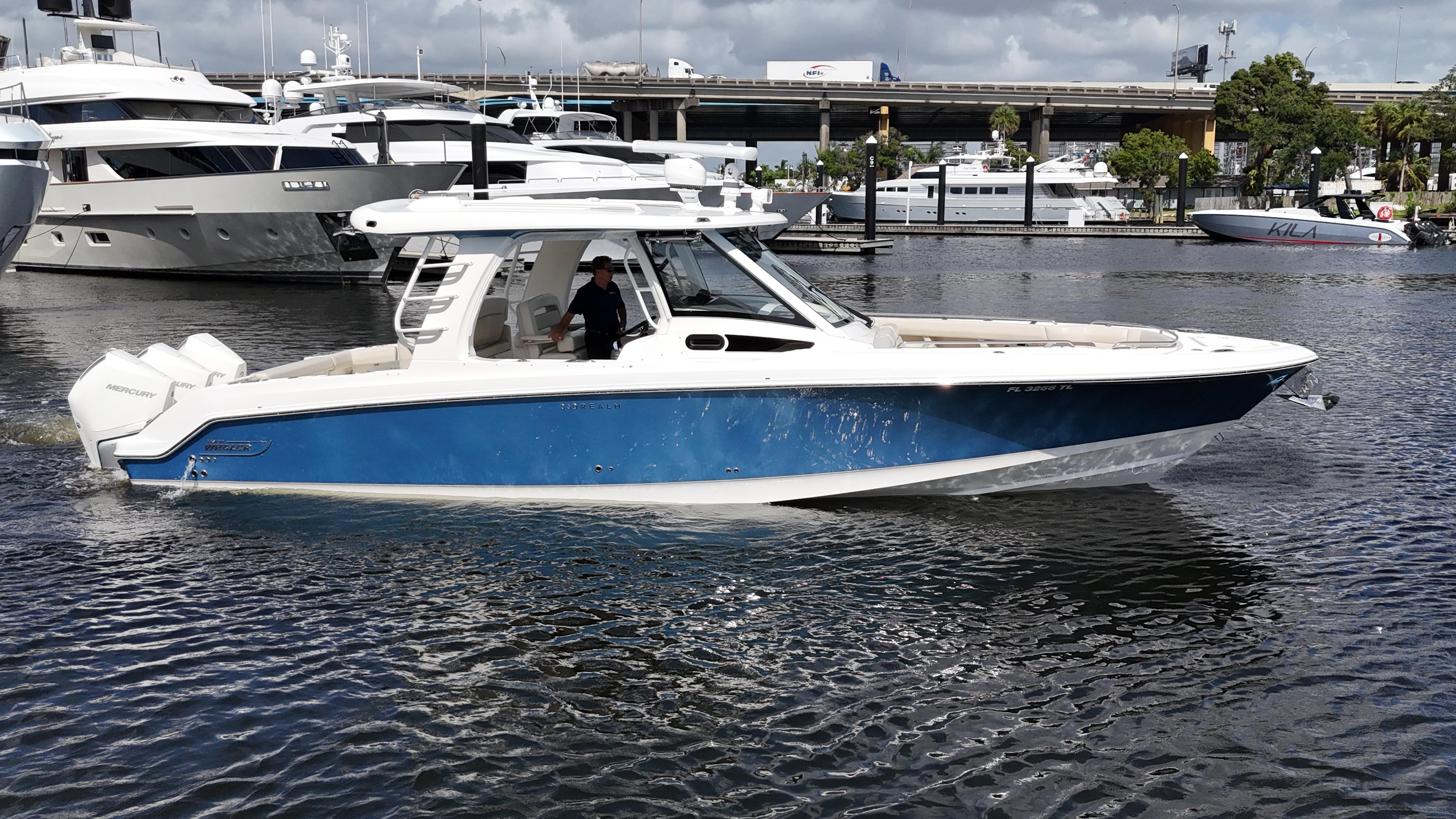 Boston Whaler 350 Realm 2020 Boston Whaler 350 Realm boat cruising in a marina, featuring a sleek blue and white design.