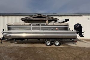 Sun Tracker Party Barge 24 DLX 2024 Sun Tracker Party Barge 24 DLX pontoon boat on trailer, parked outdoors.