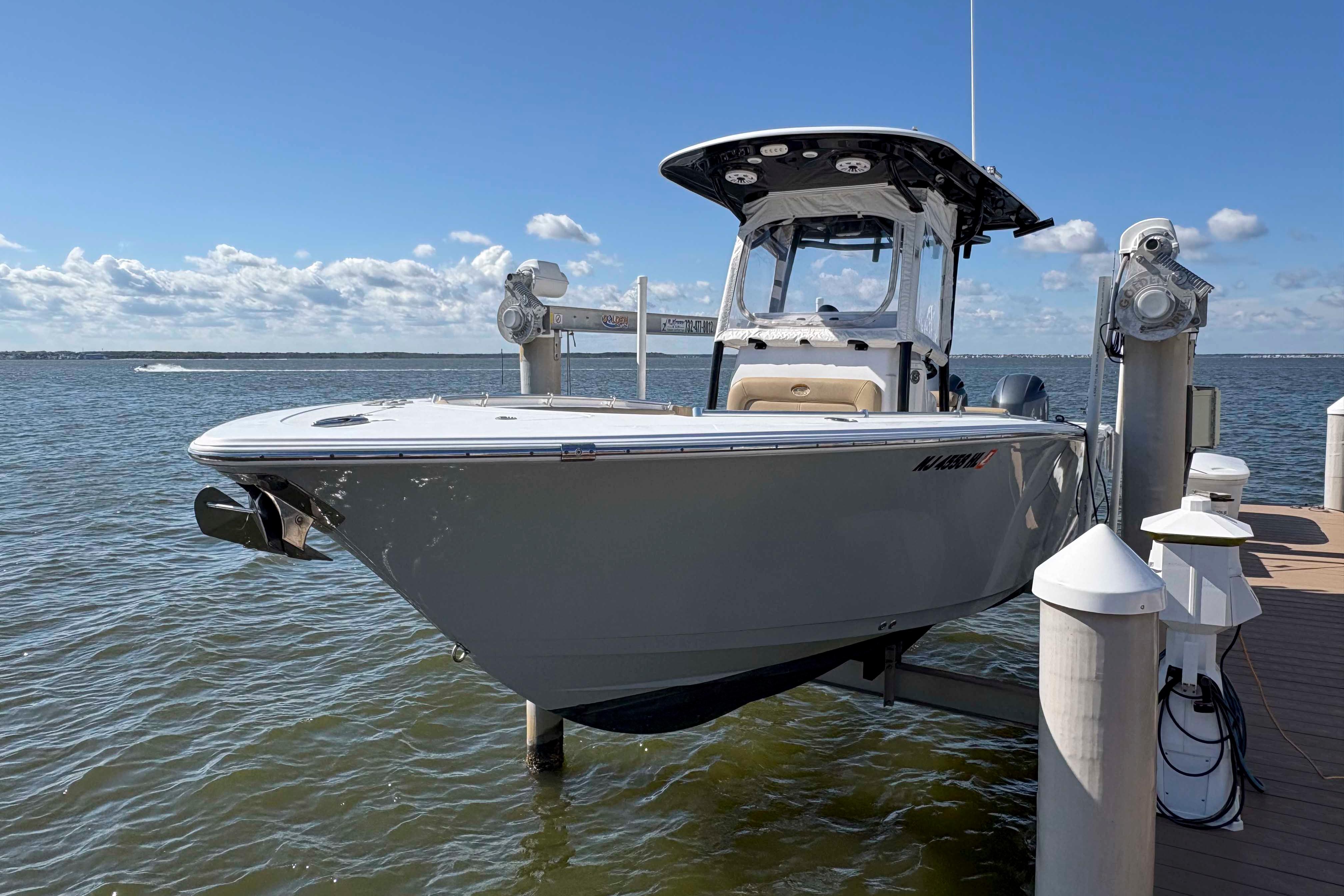 Sportsman Open 252 Center Console 2018 Sportsman Open 252 Center Console boat docked on a lift by the water.