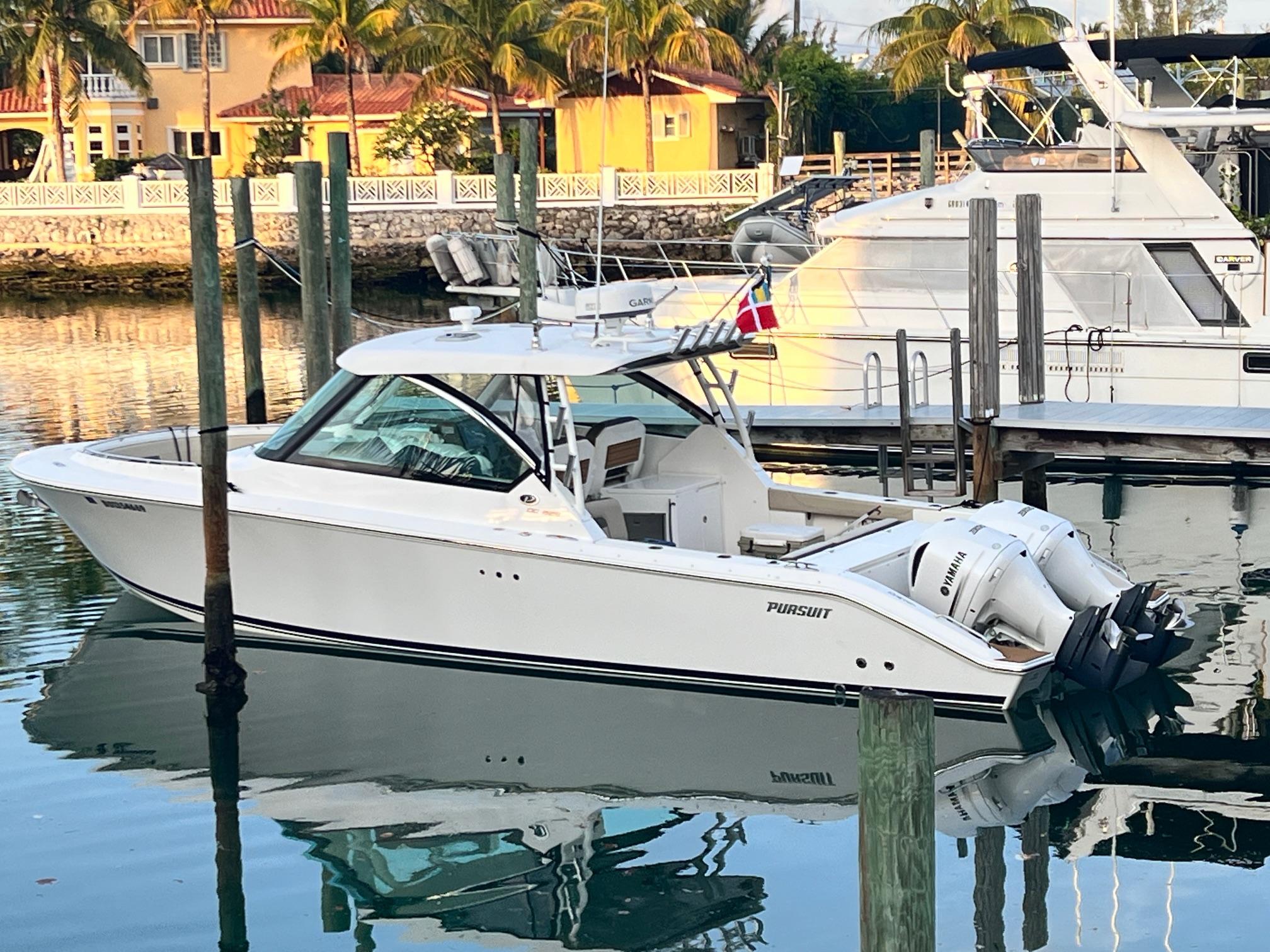 Pursuit 325 DC 2019 Pursuit 325 DC boat docked in a serene marina setting.