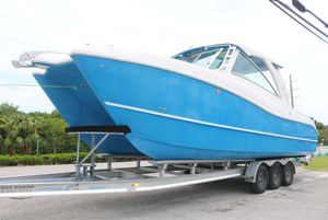 World Cat 320 DC 2017 World Cat 320DC boat on a trailer, blue and white design, parked outdoors.