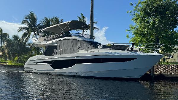 Galeon 500 Fly 2019 Galeon 500 Fly yacht docked by palm trees and water.