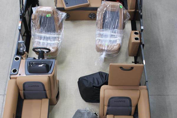 Harris Cruiser 210 2025 Harris Cruiser 210 interior with tan seating, steering console, and protective coverings.