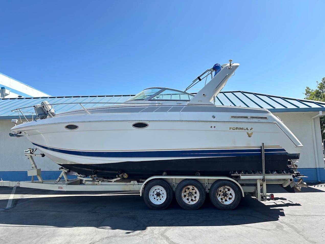 Formula 27 PC 2002 Formula 27 PC boat on trailer, parked outdoors under clear blue sky.