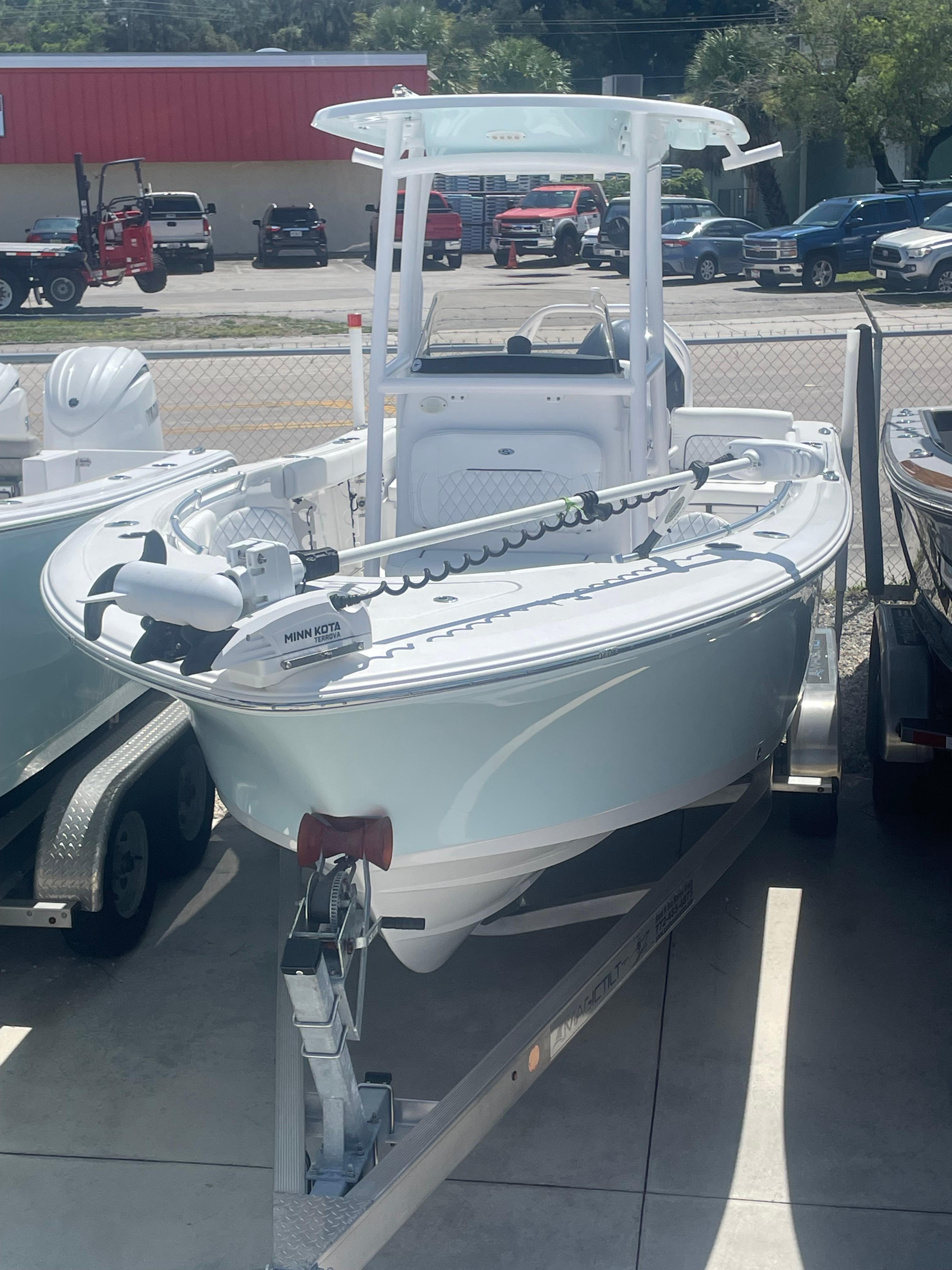 Sportsman Heritage 231 2023 Sportsman Heritage 231 boat on trailer, displayed outdoors in a dealership lot.